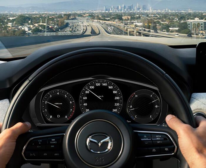 Point de vue d’un conducteur avec les mains sur le volant dans un véhicule en mouvement.