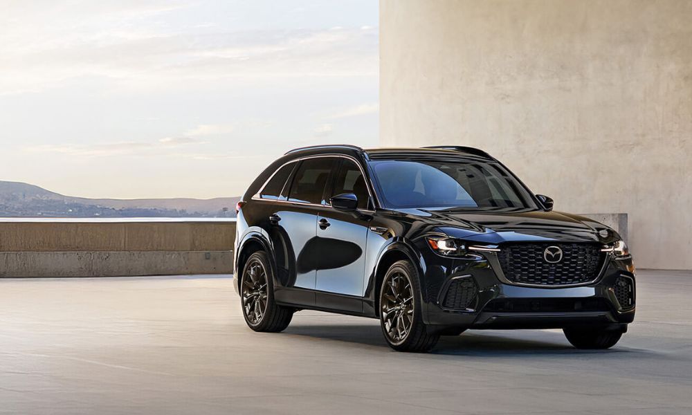 Un CX-70 hybride rechargeable blanc garé à une borne de recharge.