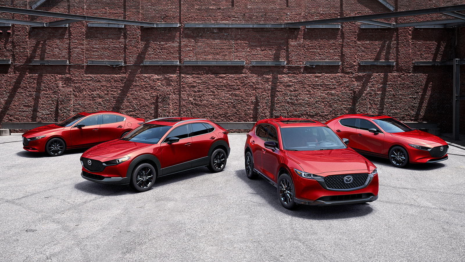 Divers modèles Mazda dans une salle d’exposition, dont une berline Mazda3, une Mazda6 et un CX-5.