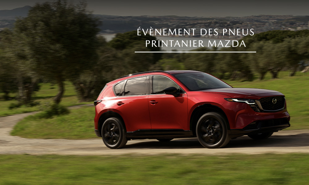 Un Mazda CX-5 rouge stationné dans un champ verdoyant