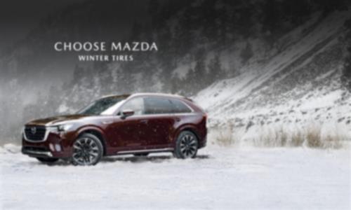 A Mazda CX-90 driving on a snowy road