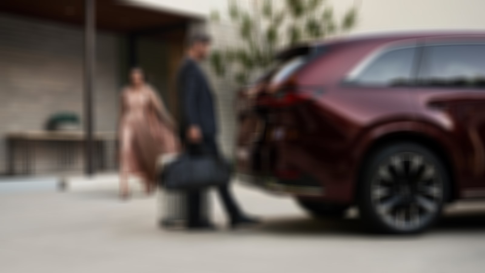 Man with hands full of luggage uses foot to operate rear power liftgate.