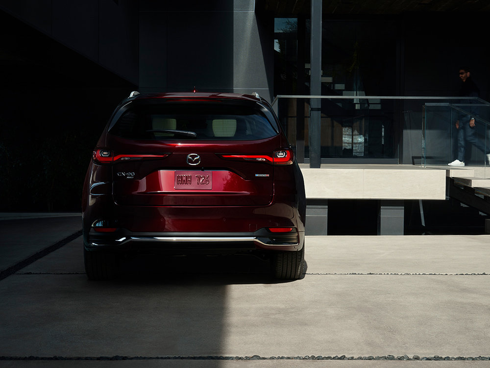 CX-90 rear liftgate ajar reveals cargo space. 