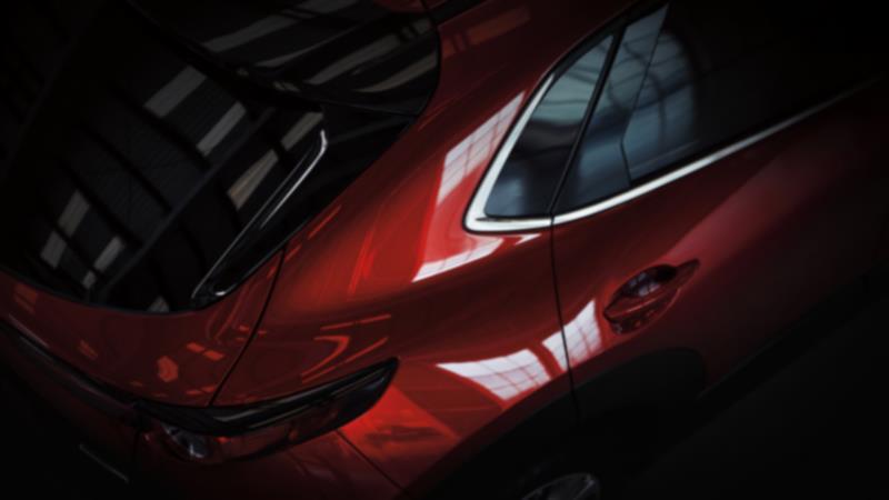 Close up of back ¾ Soul Red Crystal Metallic CX-30 from above, parked in studio environment. 