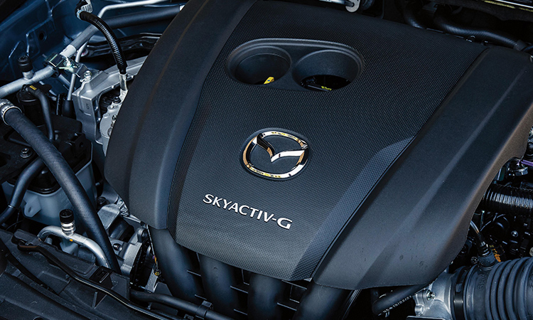 À l’intérieur du capot du CX-30, un couvercle de moteur avec le logo Mazda et l’insigne Skyactiv-G. 