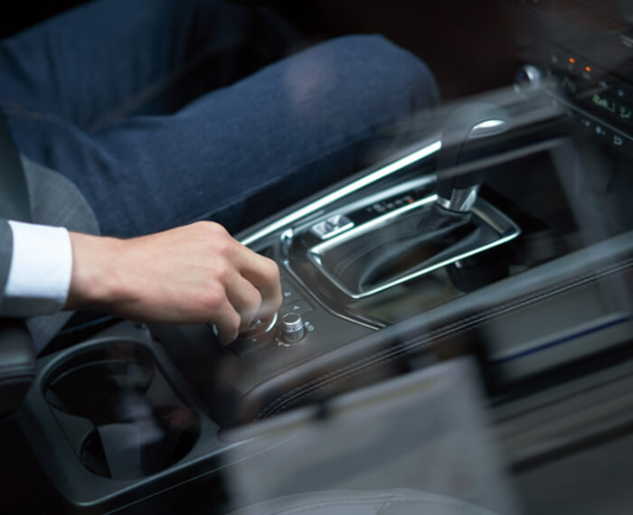 La main droite du conducteur qui ajuste le bouton du poste de contrôle HMI. 