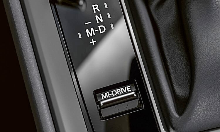 Gros plan du commutateur Mi-Drive, du levier de vitesses et du bouton multifonction du poste de contrôle HMI sur la console centrale d’un CX-50. 