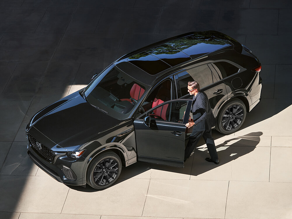 Top-down shot, driver enters CX-70 Inline 6 Turbo.