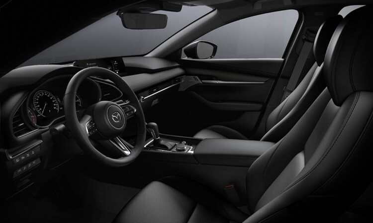 Comfortable front seating in the Mazda3 sedan, driver’s window POV looking across seats. 