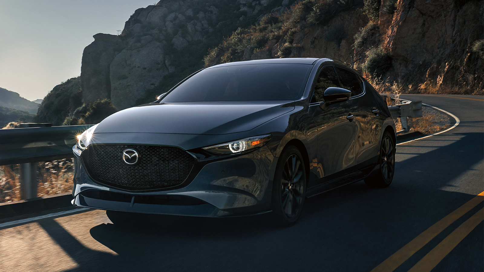 Driver stepping into a Mazda3 Sedan on cobblestone entryway in front of large limestone building. 