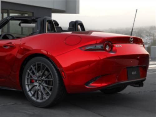 Close-up of the back of a red MX-5 ST with its top down.