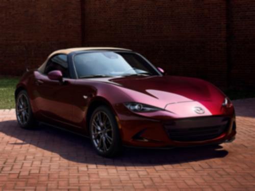 3/4ths view of a parked MX-5 ST 35th Anniversary Edition in red.