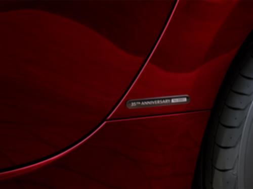 Close-up of the 35th Anniversary badge on a red MX-5 ST. 