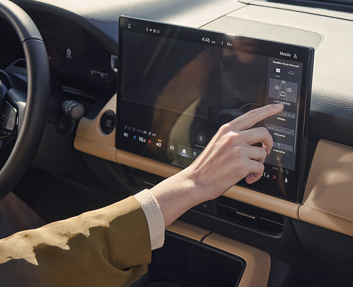 Une main utilisant l’écran tactile central du Mazda CX-5.