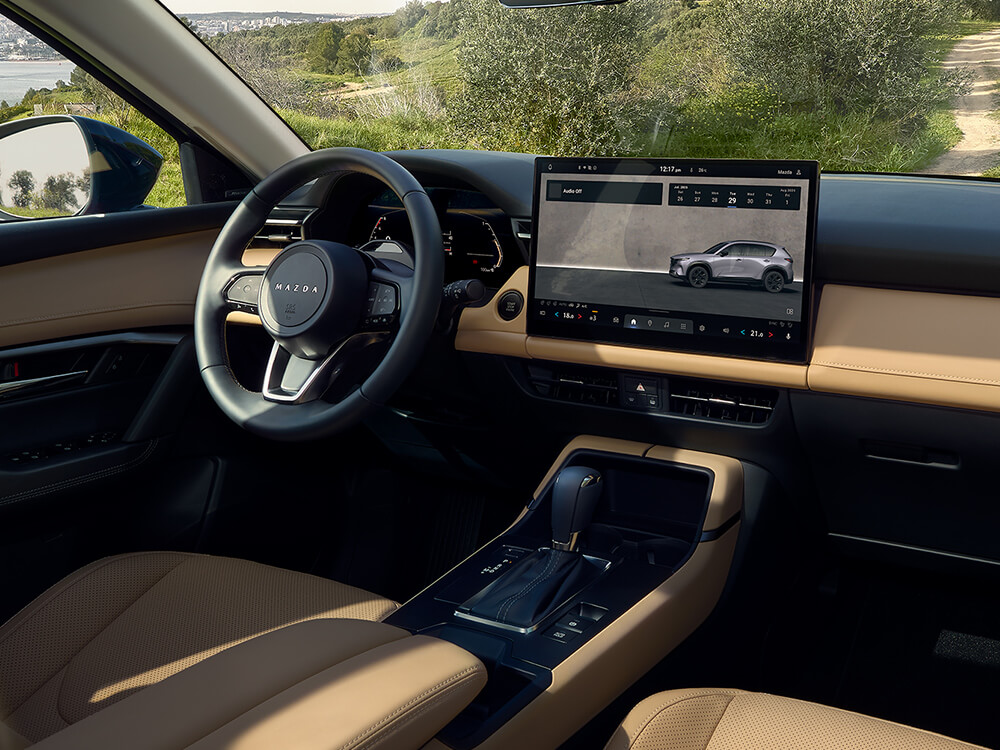 Intérieur d'un Mazda CX-5 montrant le volant et l'écran tactile.