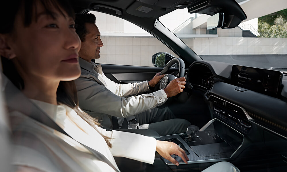 Side profile of a woman and man driving the CX-70.