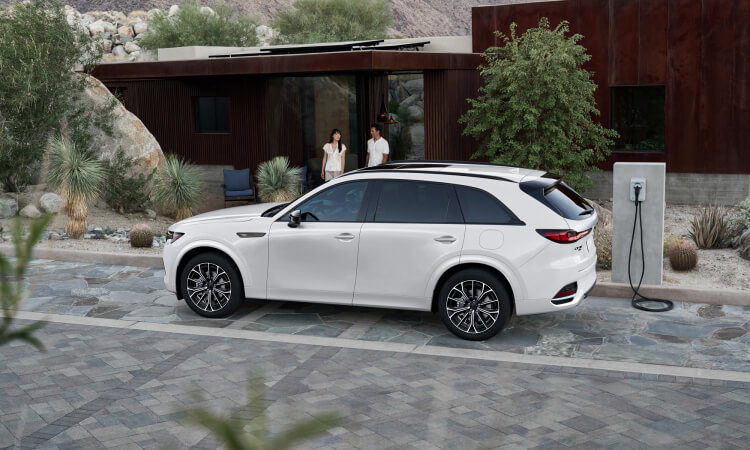 Side profile of the CX-90 at a charging station.