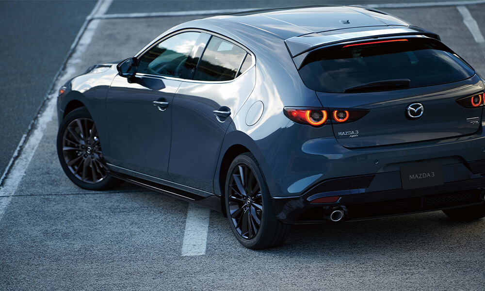 Le coin du siège arrière du côté conducteur d’une Mazda3 sport bleu cristal foncé mica.