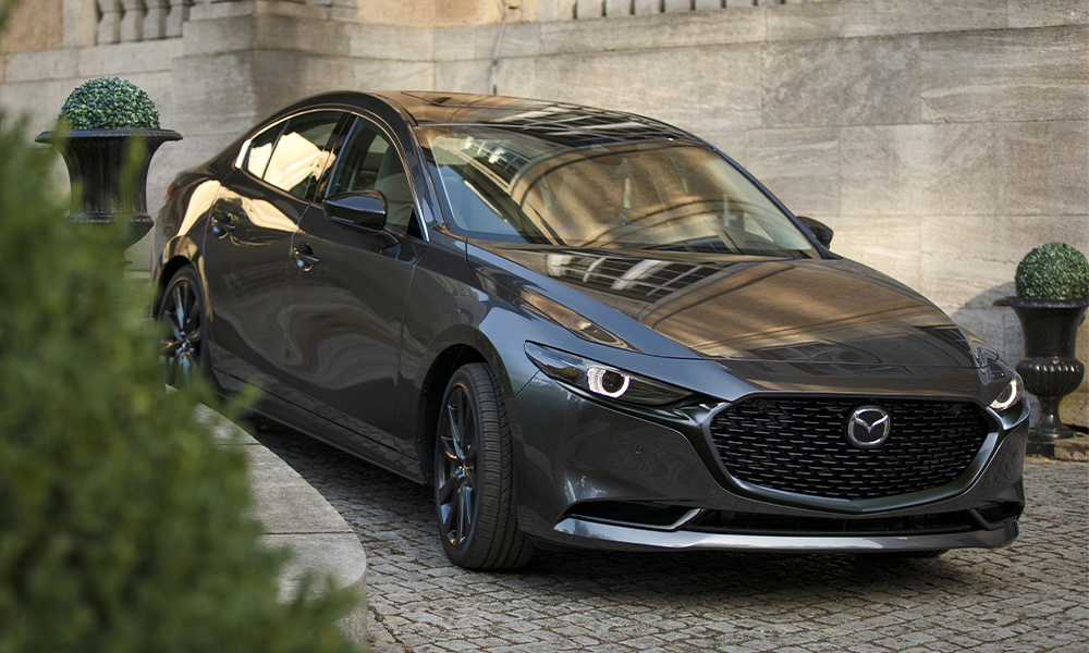 Side profile of a man entering a Machine Grey Metallic Mazda3.